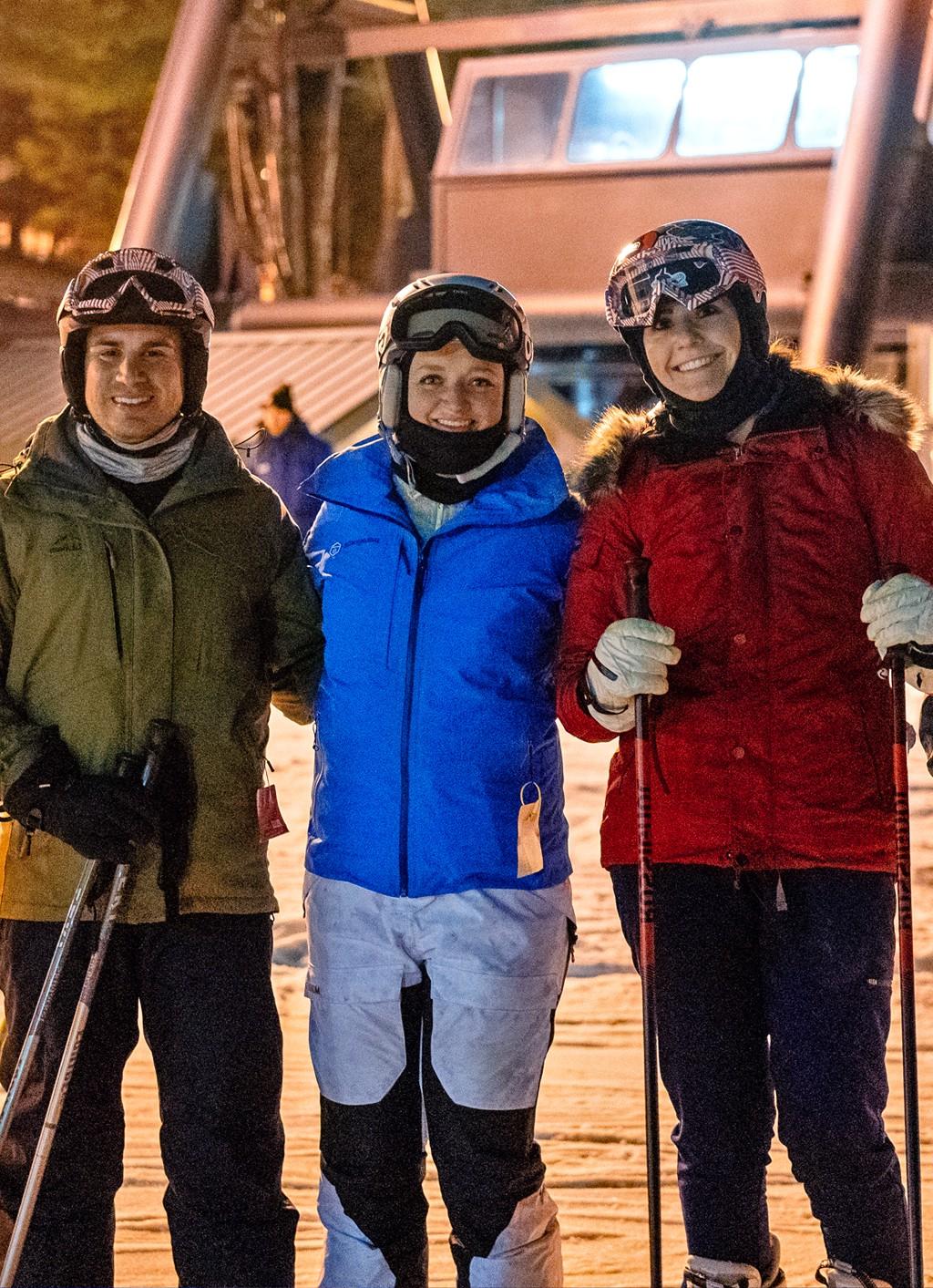 Three U N E students taking a photo on a snowy mountain during a ski trip