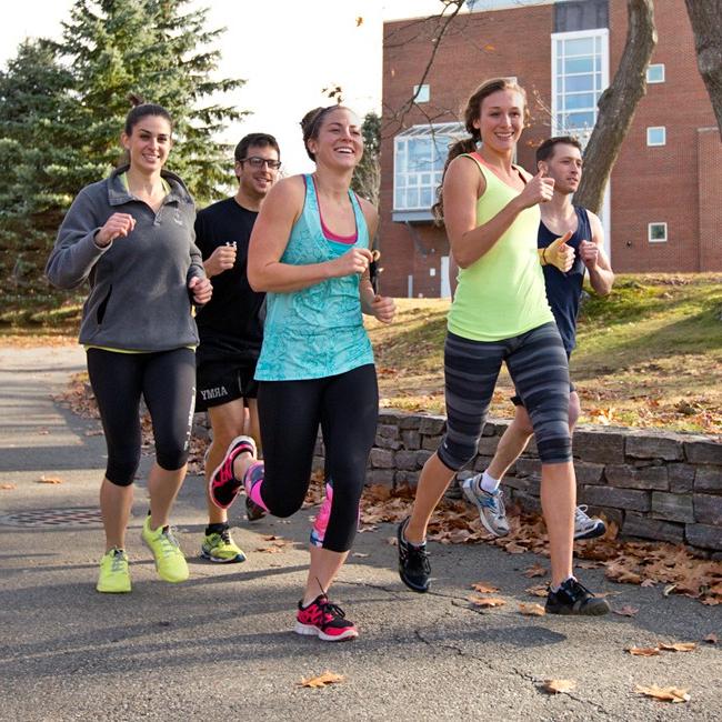A group of students running together on the Biddeford Campus