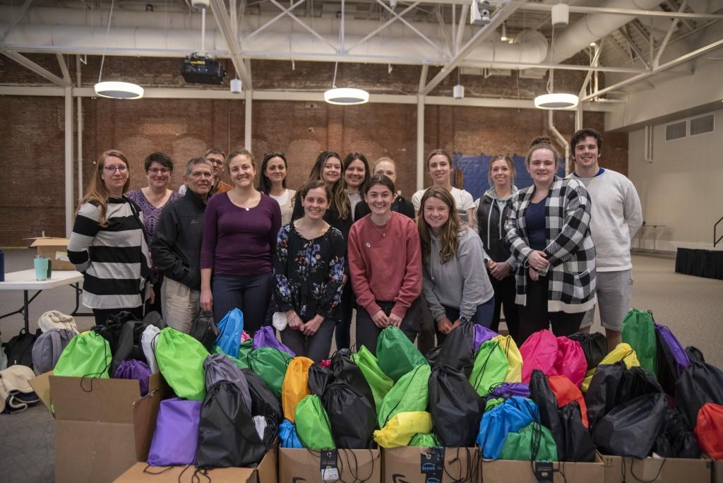 A group of students pose together for a Service-Learning program where they prepared harm-reduction bags for the Maine Correctional Facility