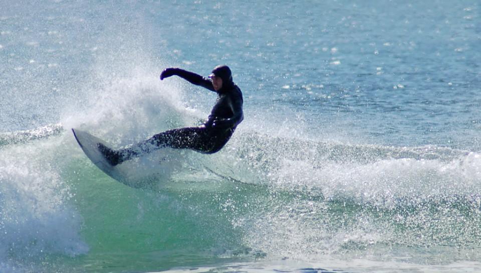 A student catching a wave while surfing