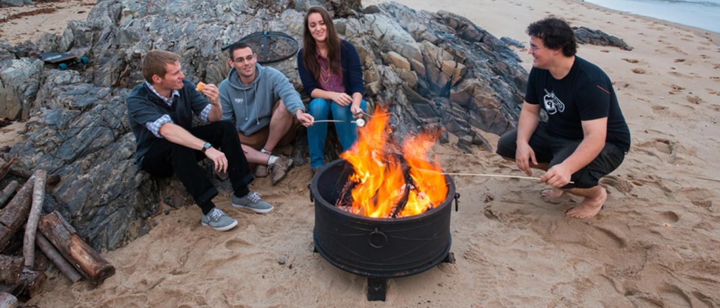 Students at a bonfire on the beach