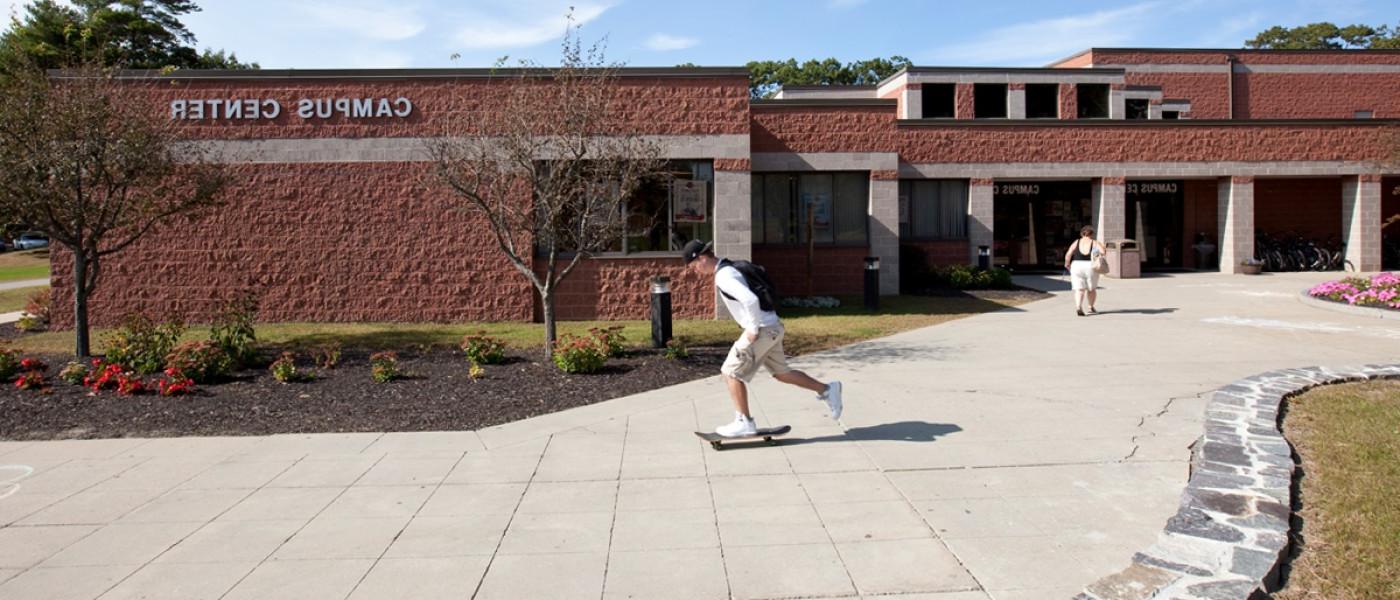 A student skateboards passed the Campus Center on the Biddeford Campus