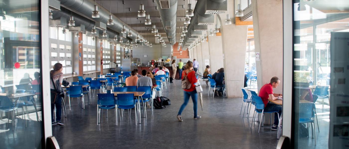 Students visit the brightly lit dining hall at Universidad Pablo de Olavide in Seville