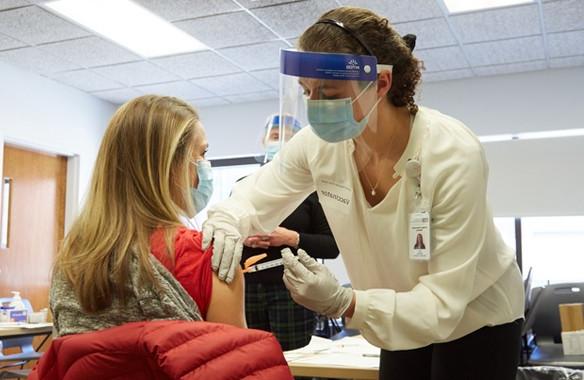 A U N E health professions student vaccinating a patient